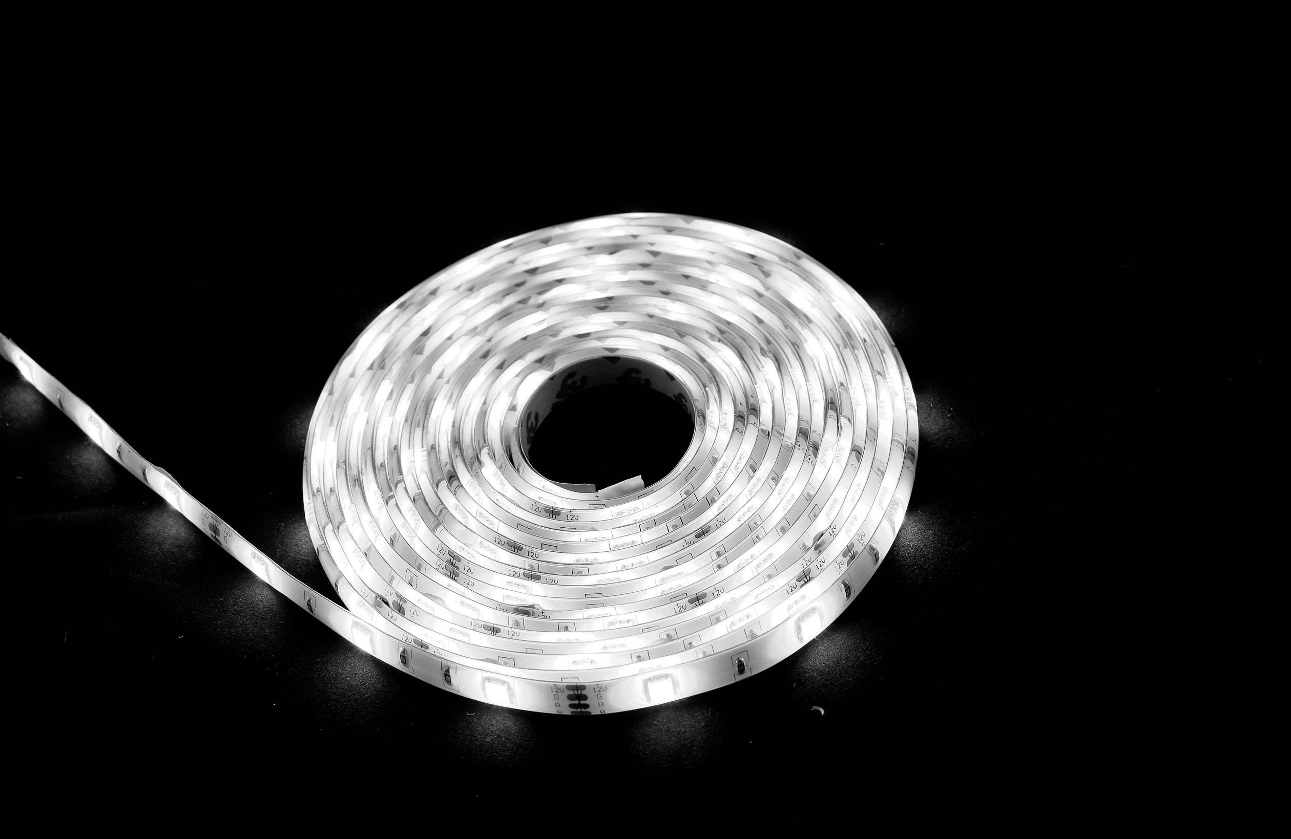 A coiled LED light string on a black background, emitting white light.