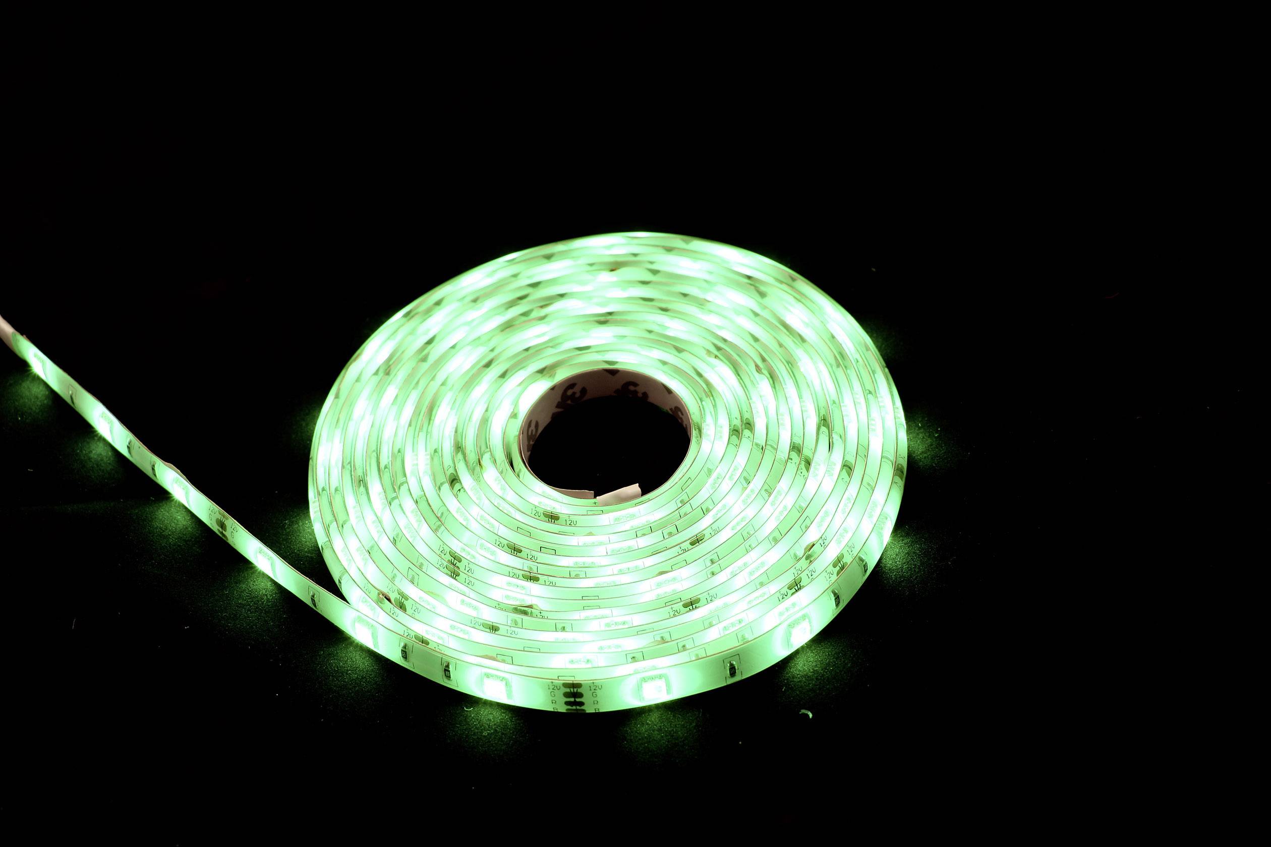 A coiled green LED light string glows brightly against a black background.