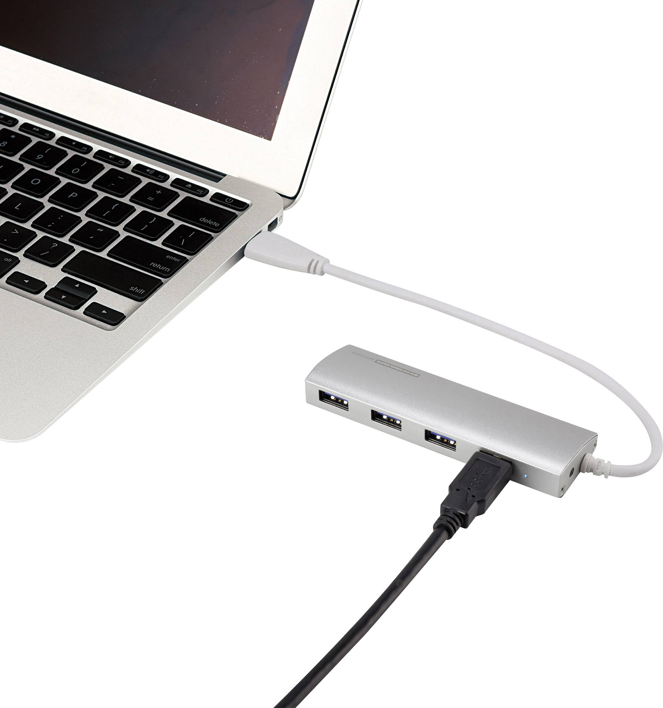 A silver laptop is connected via a USB cable to a silver USB hub, to which another black cable is connected.