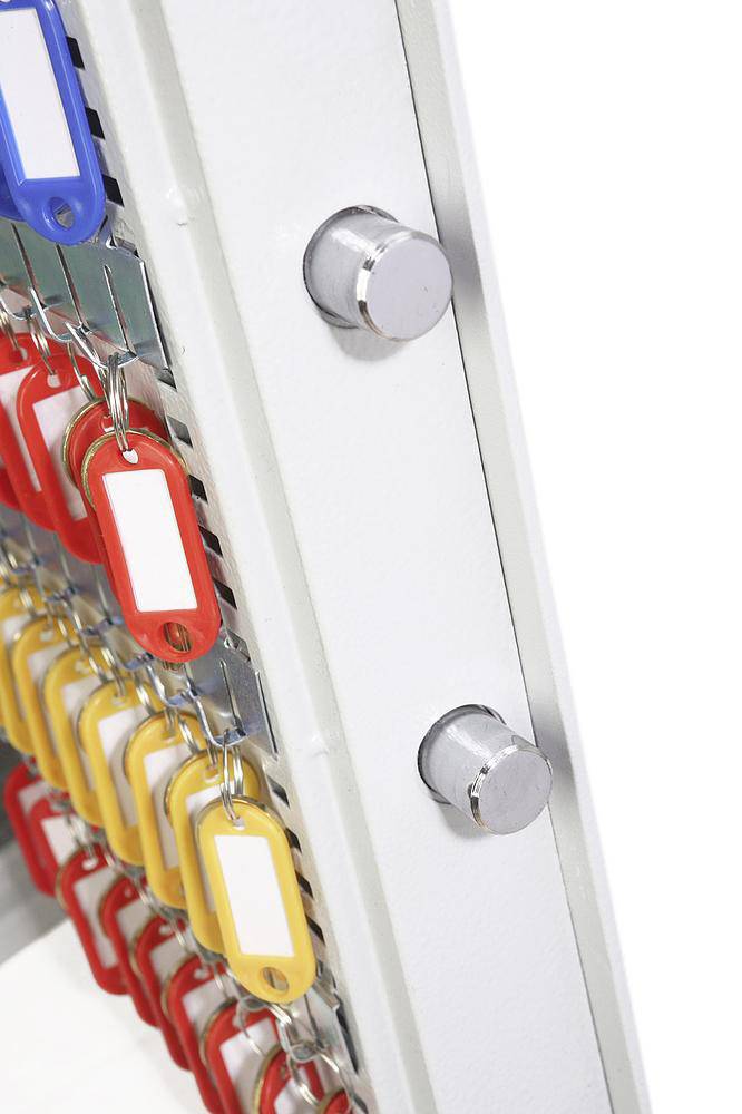 An open key cabinet with numerous keys on colourful tags, sorted in rows.