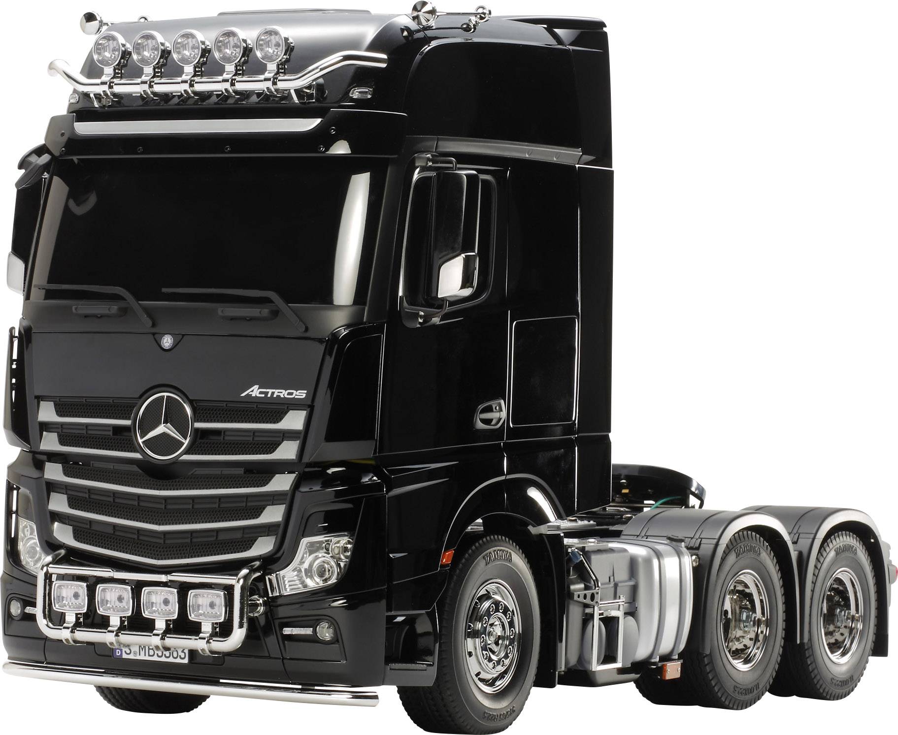Black lorry with six headlamps on the roof, gleaming radiator grille and five headlamps on the bumper, side view.