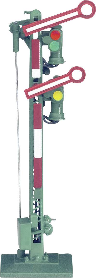 A green, mechanical railway signal with two signal arms and two lamps indicates different signal positions.