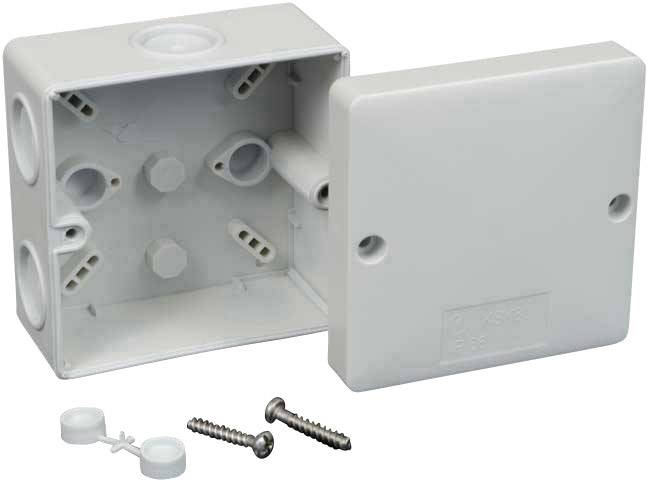 White, rectangular plastic junction box with open cover; two screws and two clamps are lying beside it.