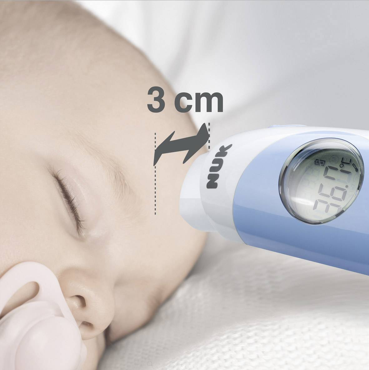 A digital thermometer measures the temperature of a sleeping baby from 3 cm away, displaying 36.7°C.