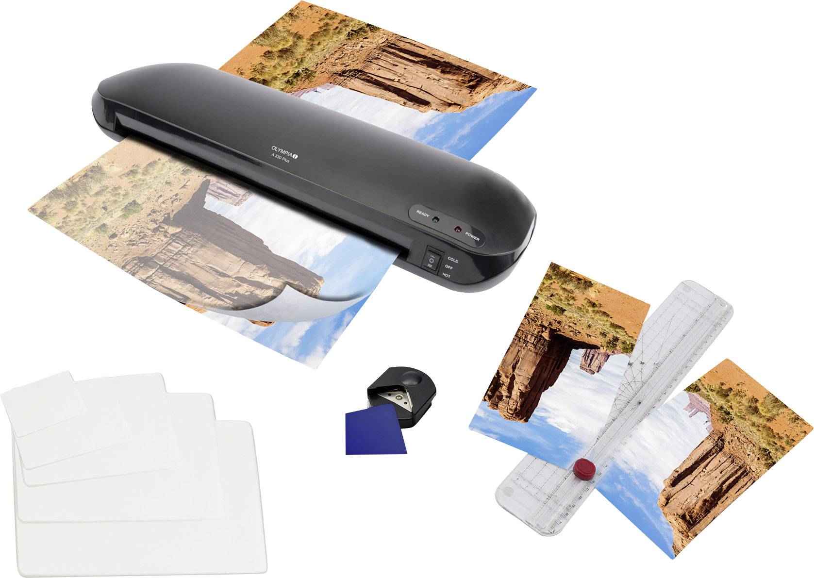 A laminating machine laminates a photo of a rocky landscape. Beside it are white sheets, a cutting device, and trimmed images.