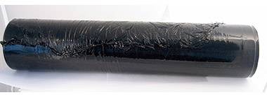 A black pipe with visible damage and cracks running across its surface.