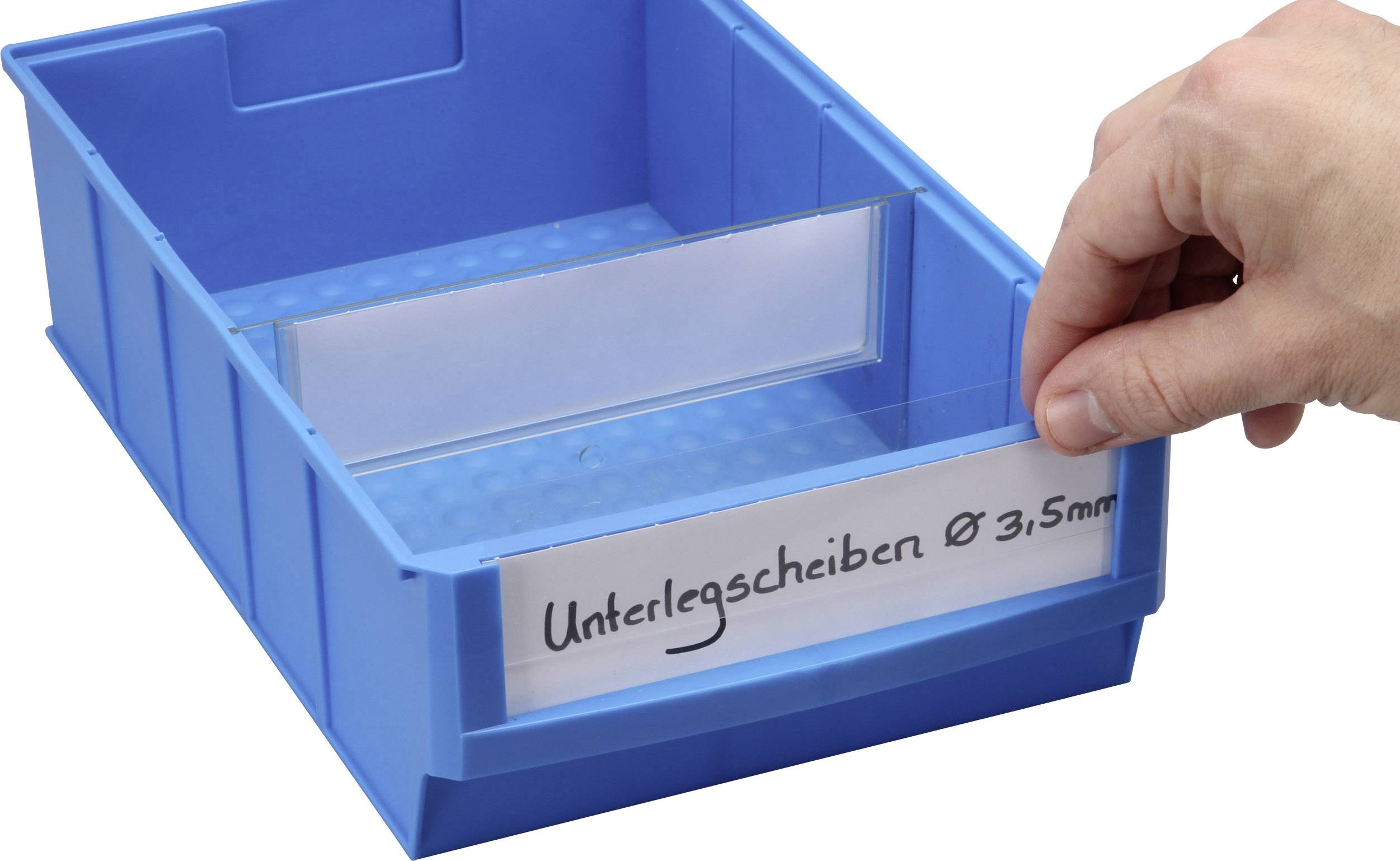 A hand places a label reading 'Washers Ø 31.5mm' into a blue storage container.