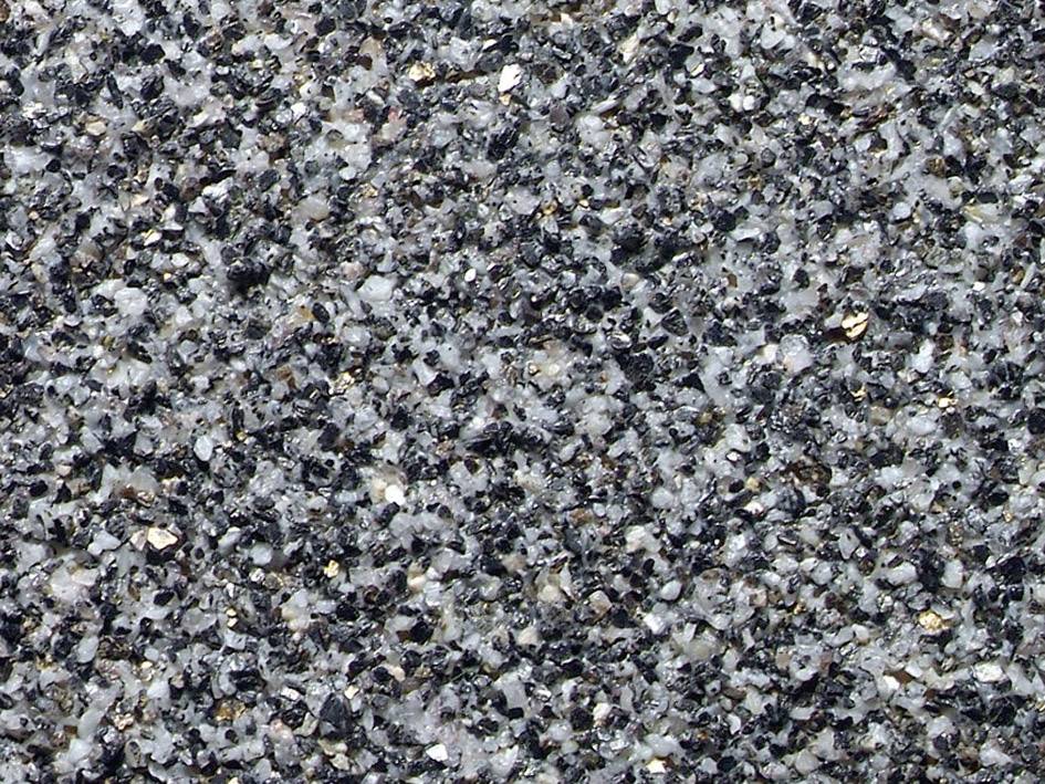 Close-up of an asphalt surface with small, irregular stones in various shades of grey.