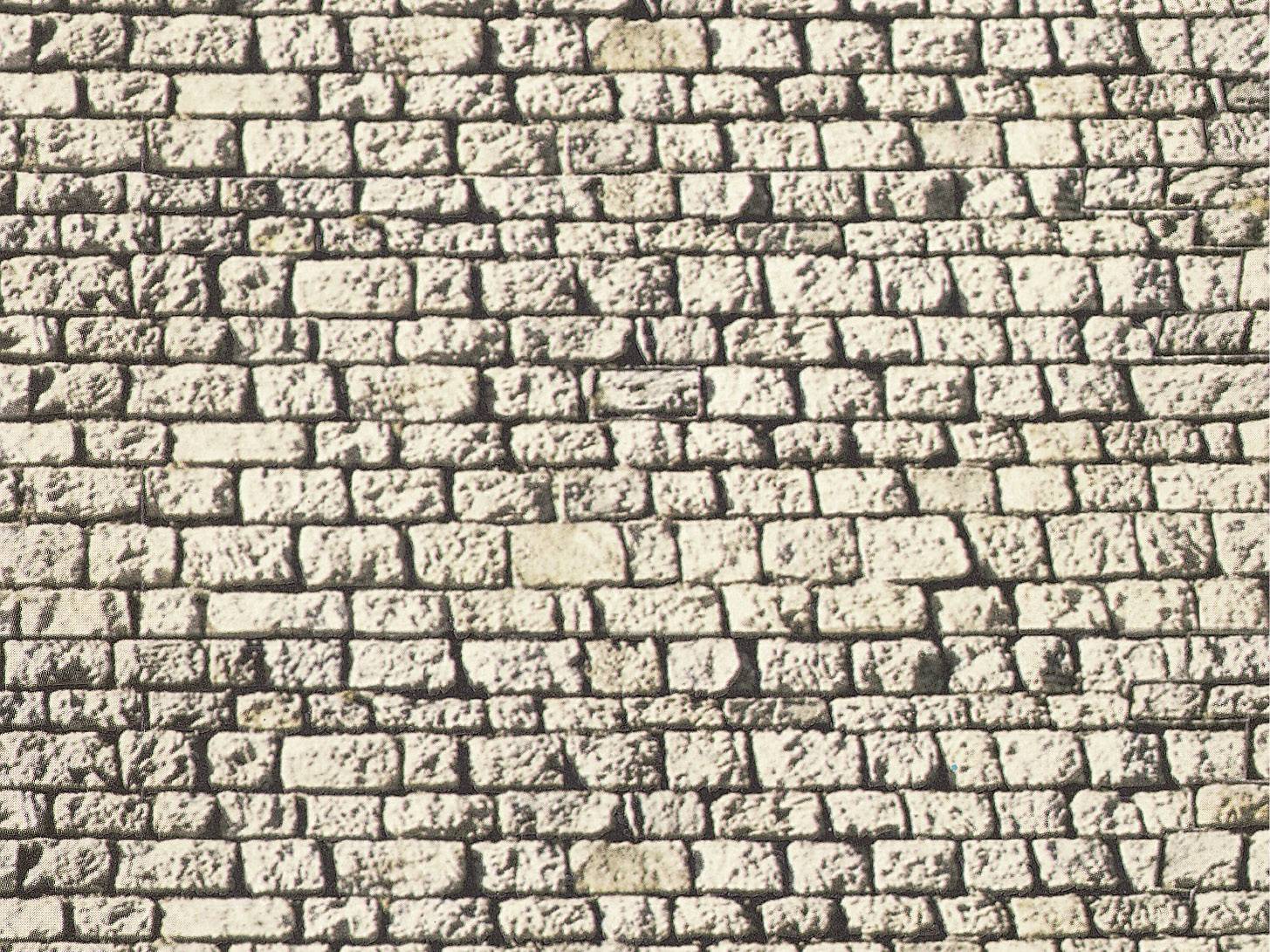 Brick wall with irregular, light-coloured stones in varying sizes. The mortar joints are thin and dark.