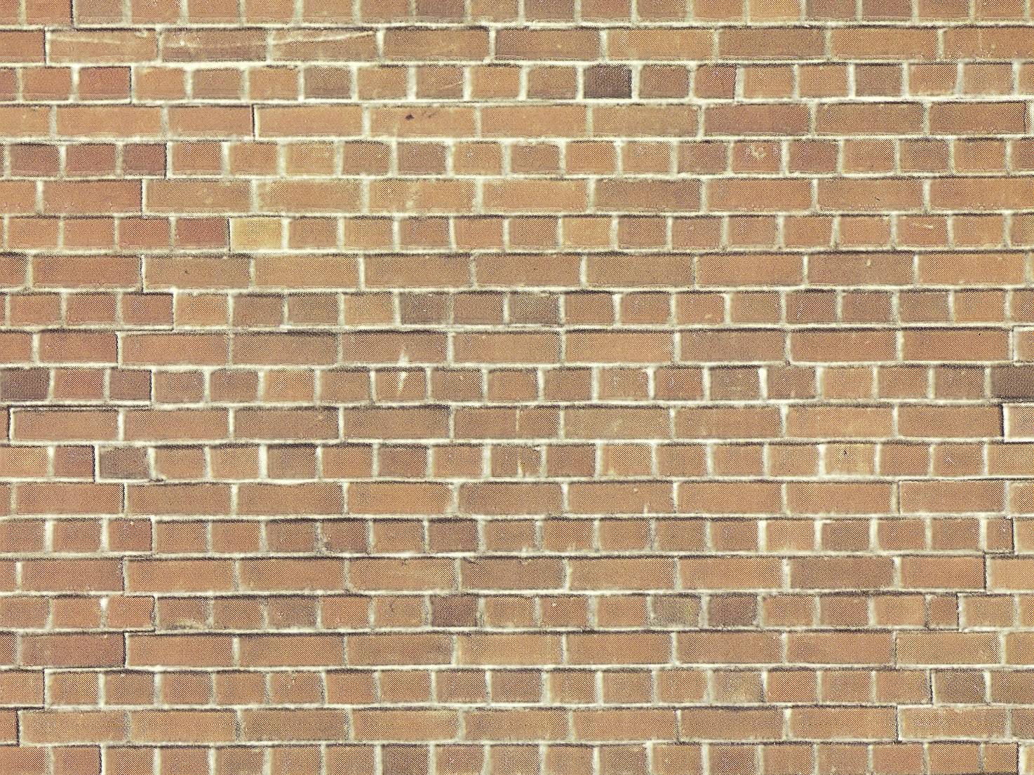 A uniform, red brick wall with a regular brickwork pattern.