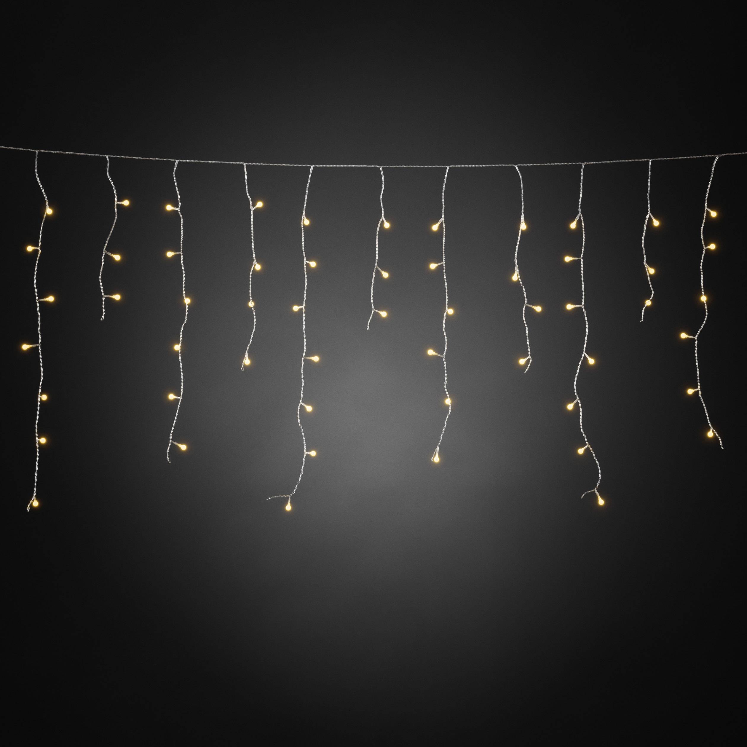 String of fairy lights with warm yellow light hanging against a dark background. The lights are evenly distributed and create a cosy atmosphere.
