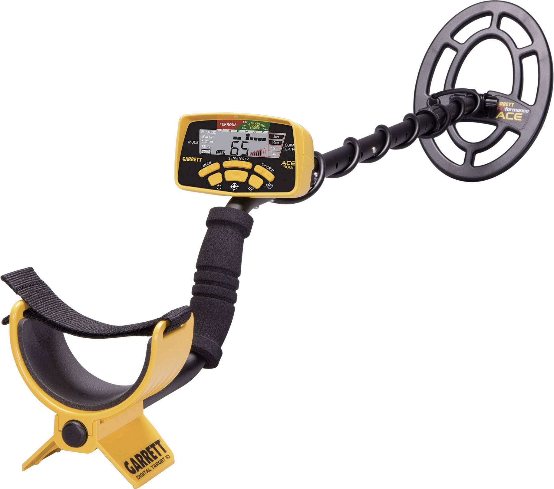A metal detector with a yellow handle and digital display. Display shows '65' and additional symbols. Device suitable for treasure hunting.