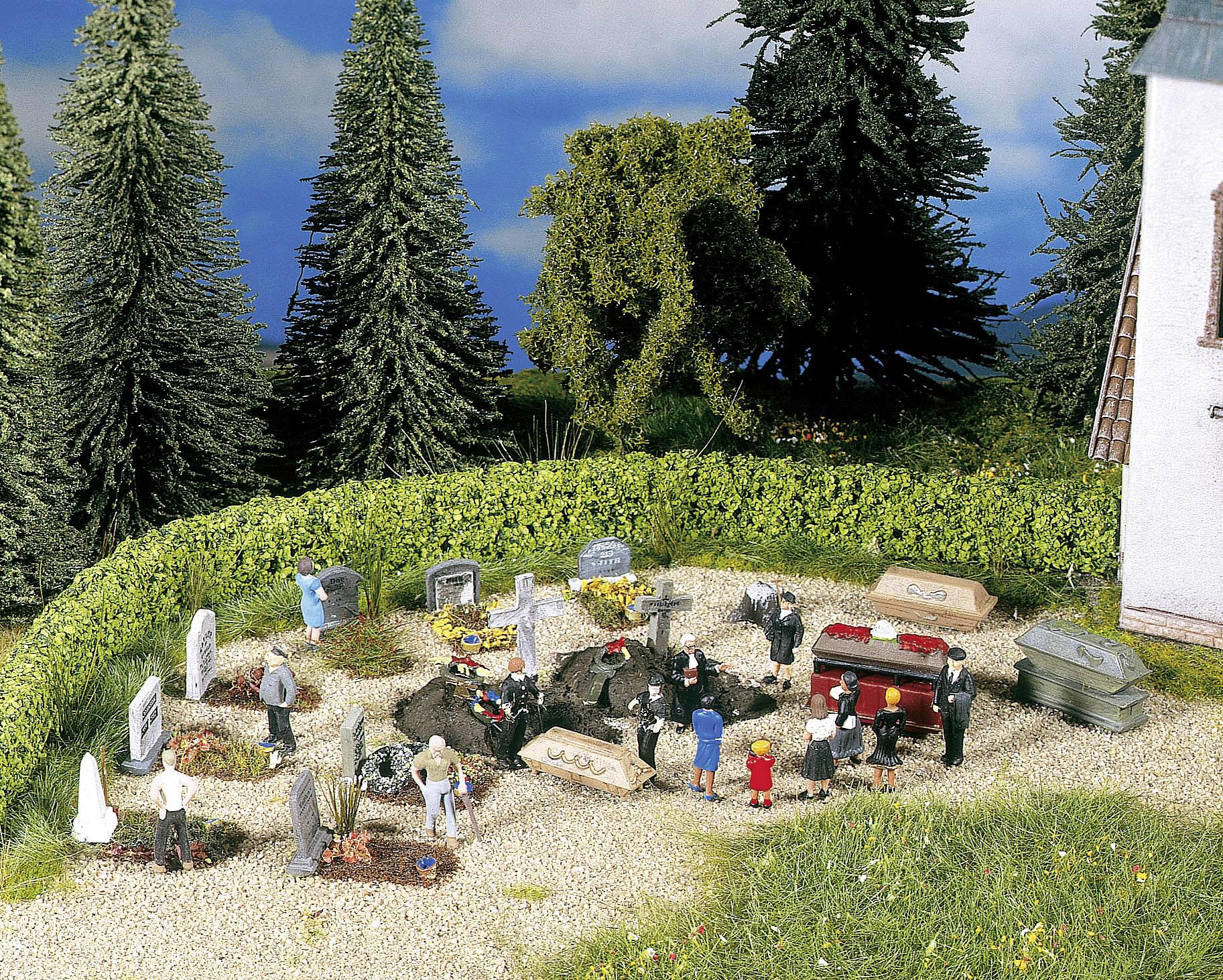 A model funeral scene: Miniature people gather around graves, some figures wearing black suits, surrounded by trees.
