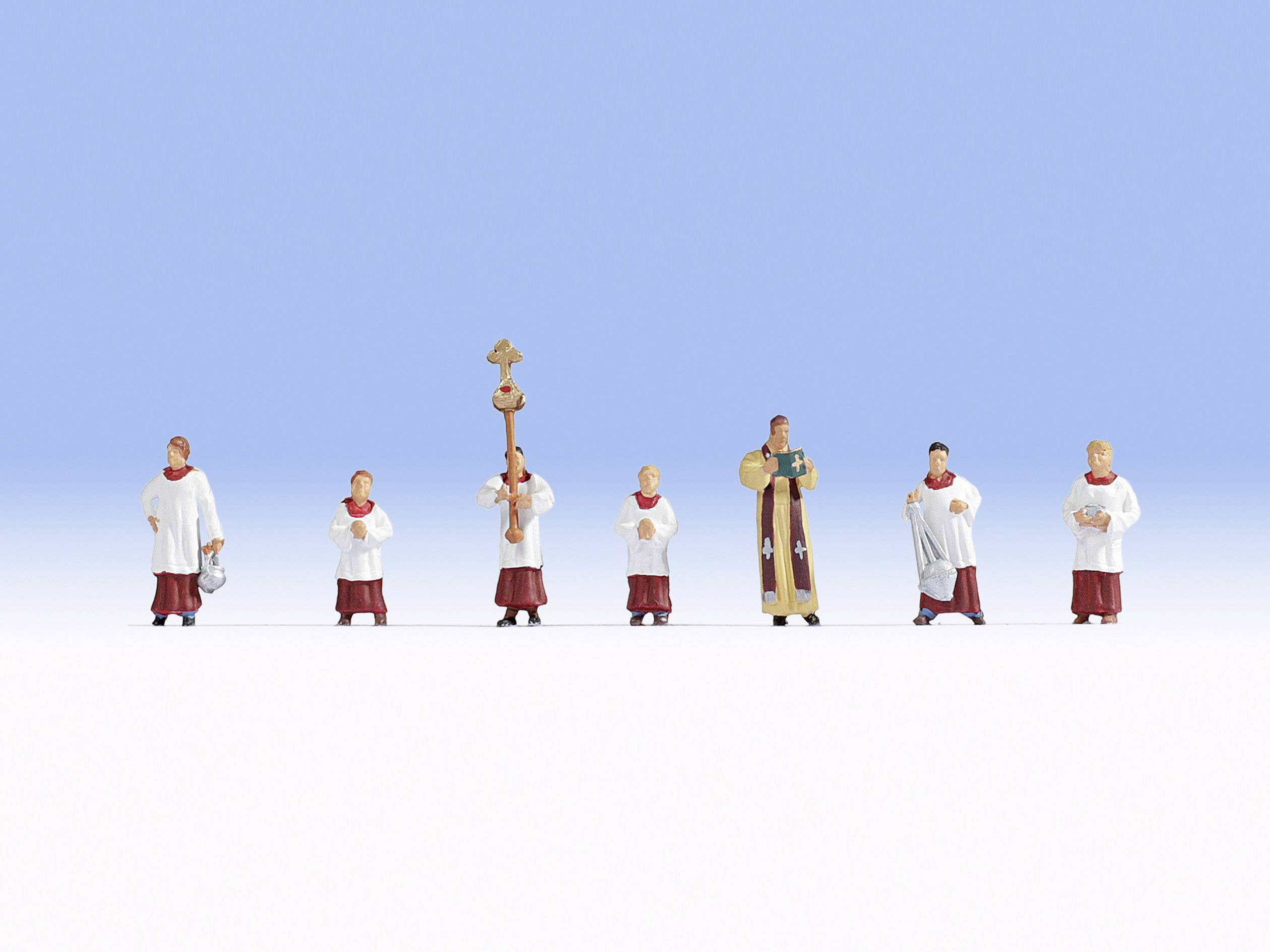 Six altar servers in red and white robes stand in a row with a priest against a blue background.
