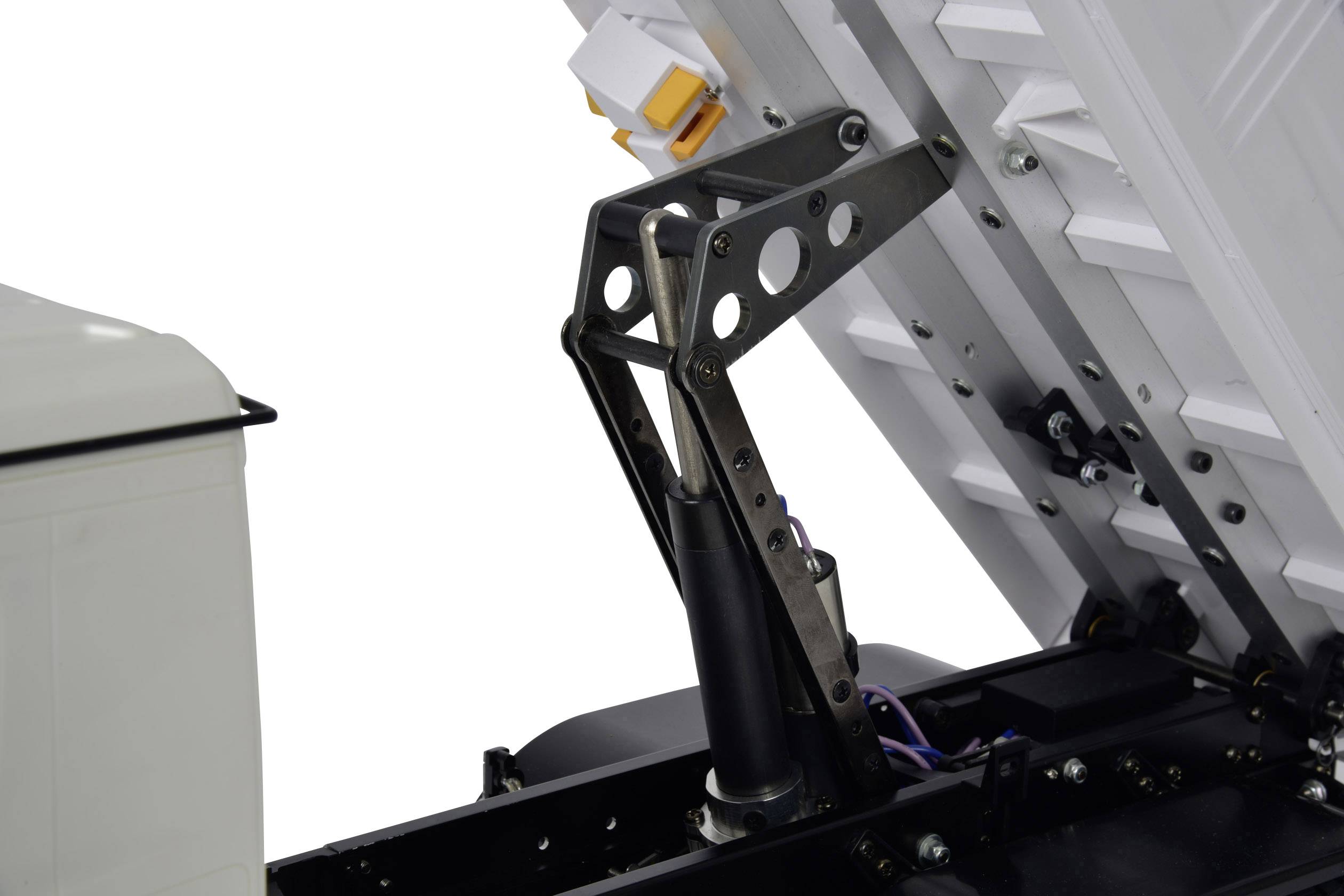 A hydraulic arm lifts a metal cover to allow a view of the underlying mechanism.