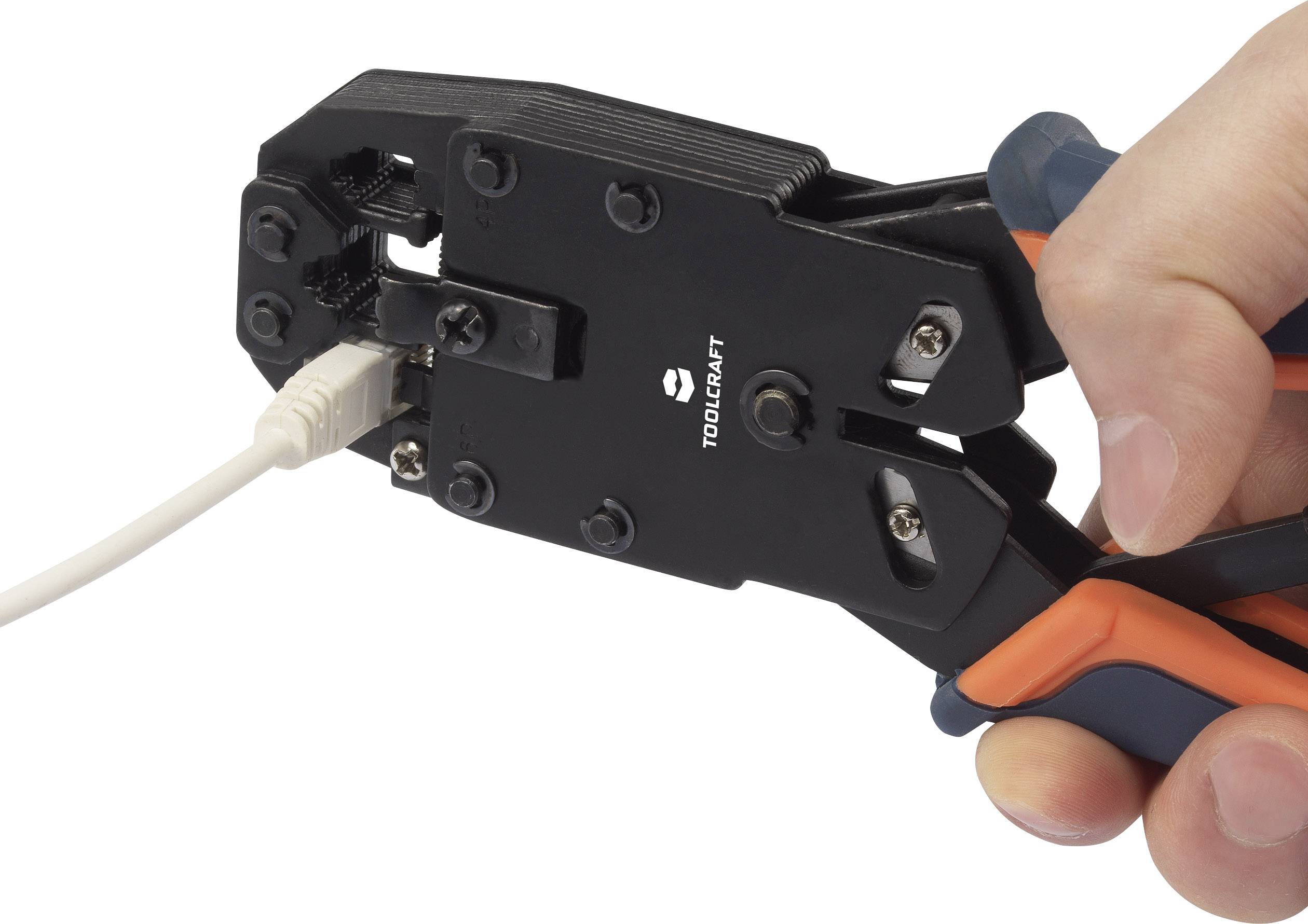 A hand holds a crimping tool that is working on a network cable.