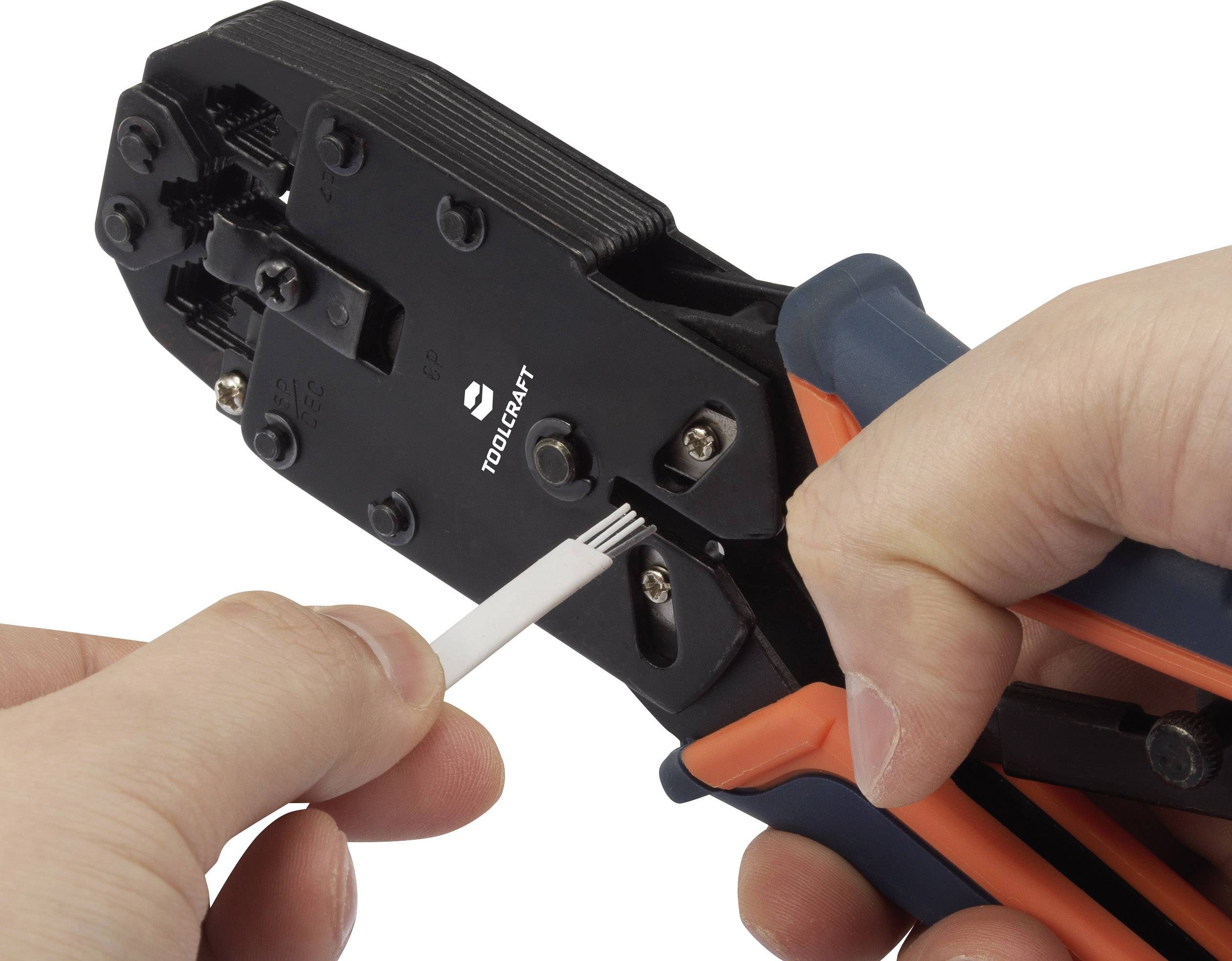 A hand is holding a crimping plier cutting a white cable tie.