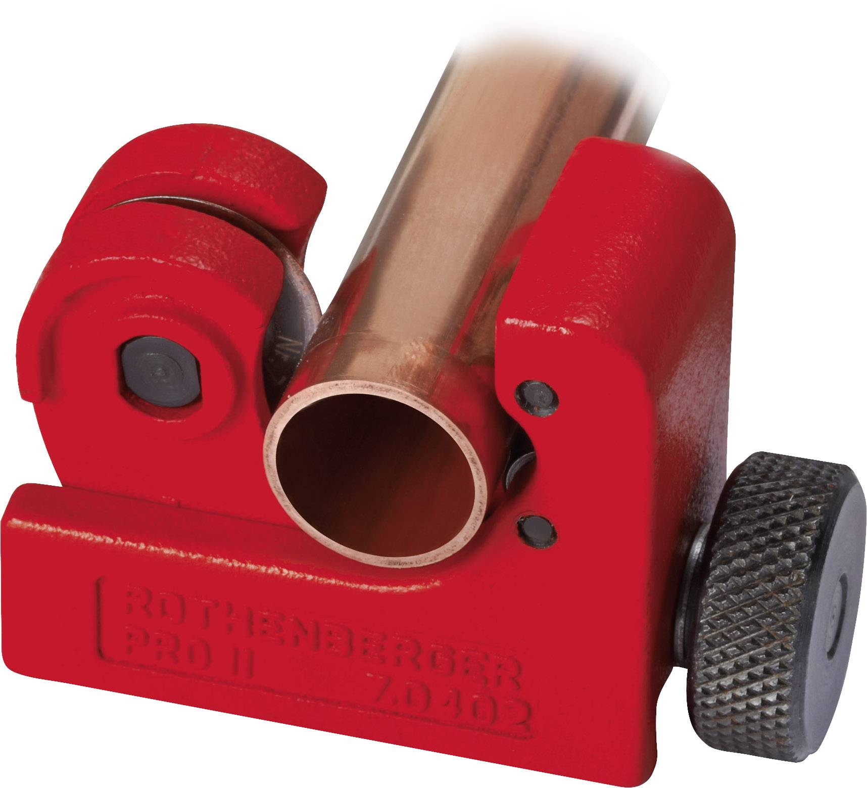 A red pipe cutter is cutting a copper pipe. The device has a screw-like mechanism for precise cutting.