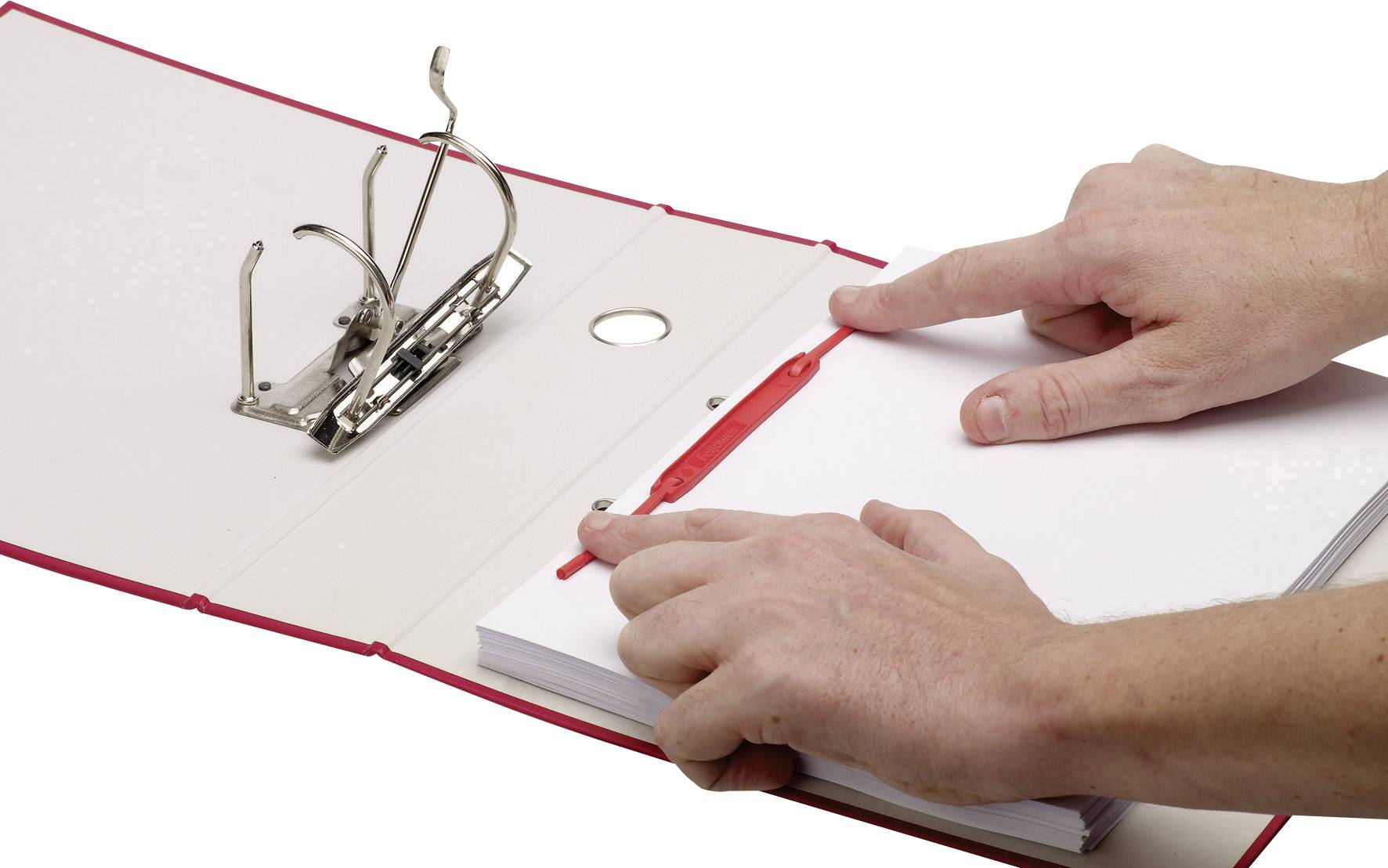 An open red ring binder is being held by two hands pointing at a stack of paper. A hole punch mechanism is visible.