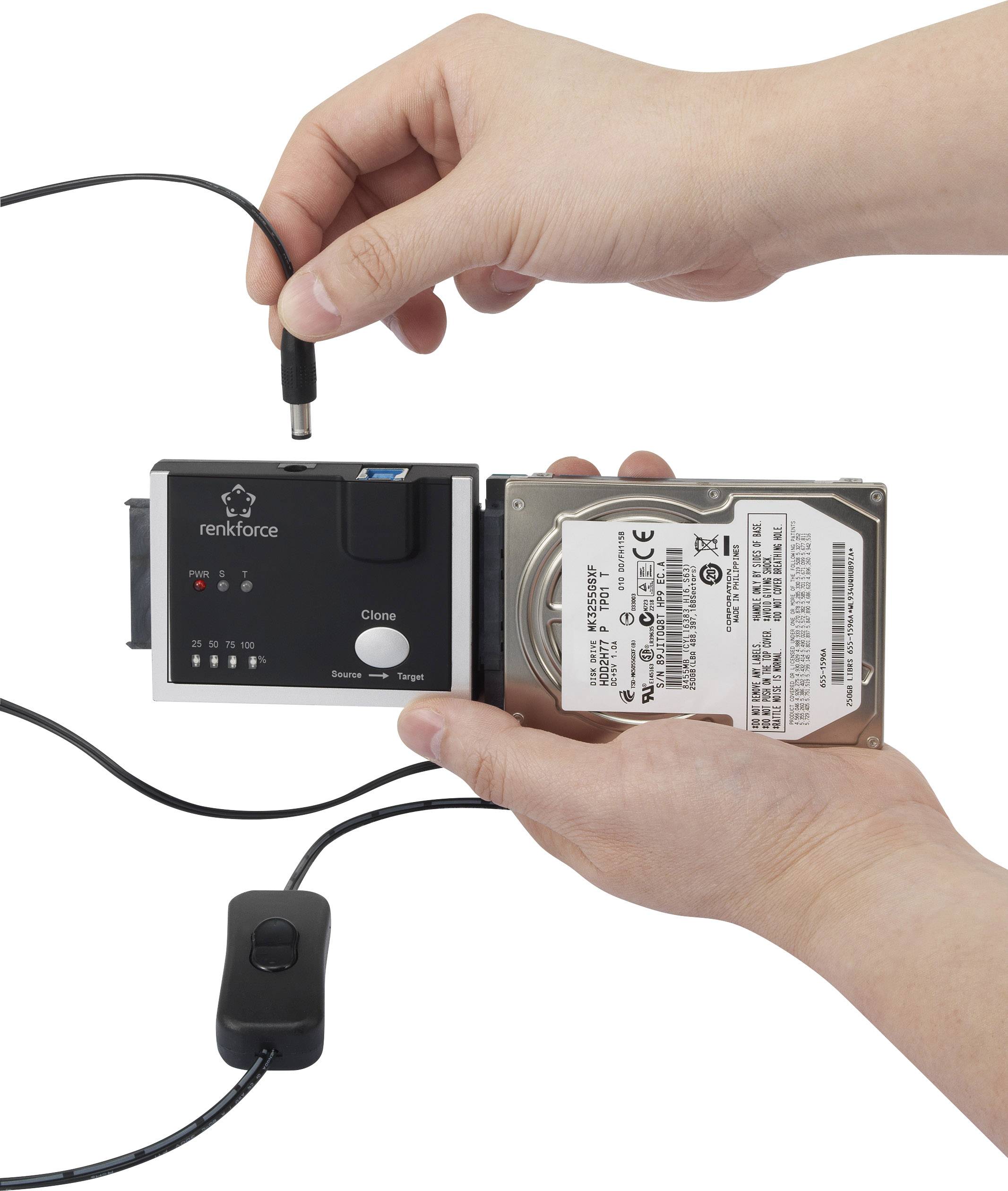 Two hands are holding a hard drive dock and a hard drive; a cable is being connected. Functions: backup and transfer.