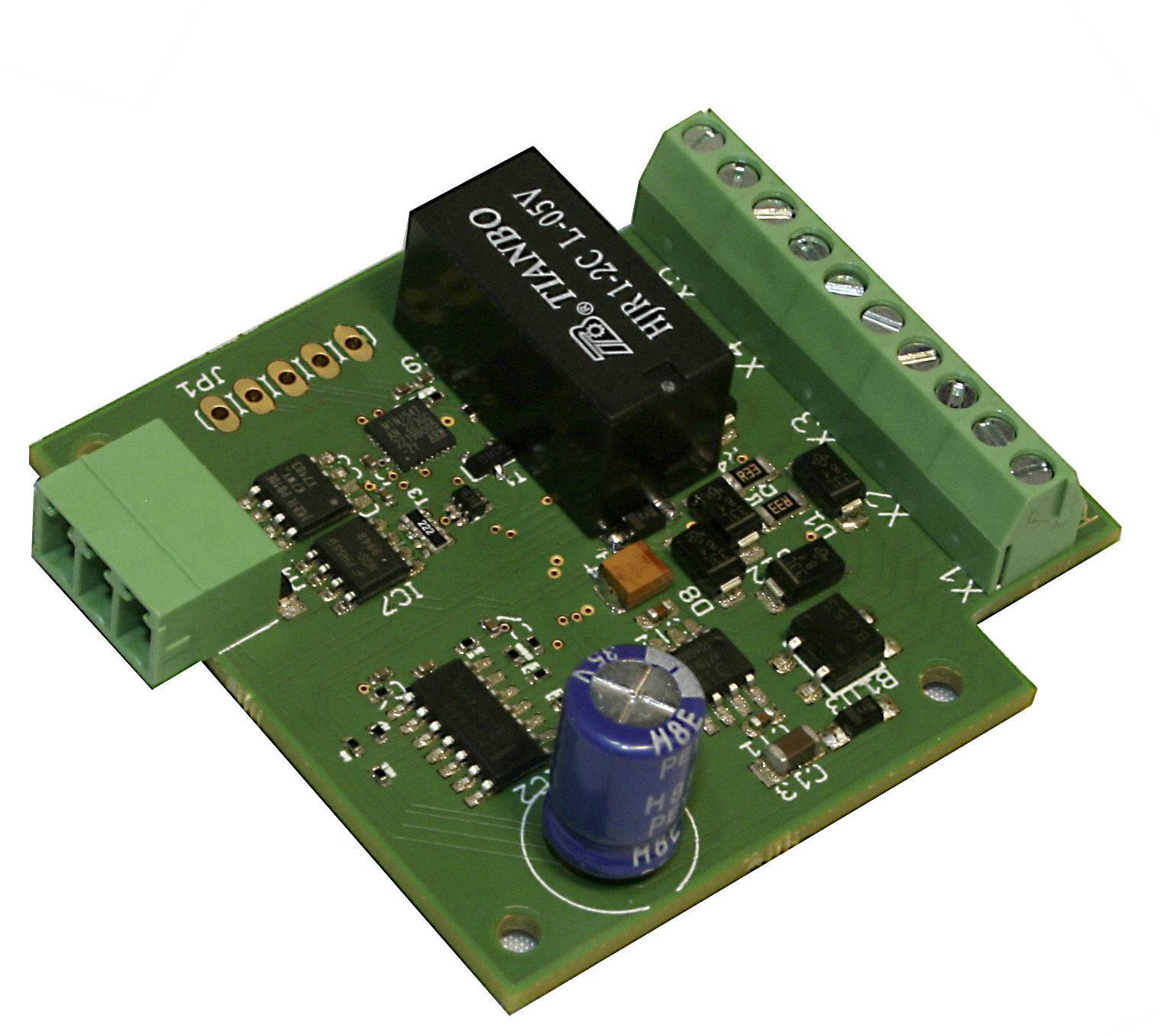 Photo of a green circuit board with multiple black and silver components and a blue capacitor.