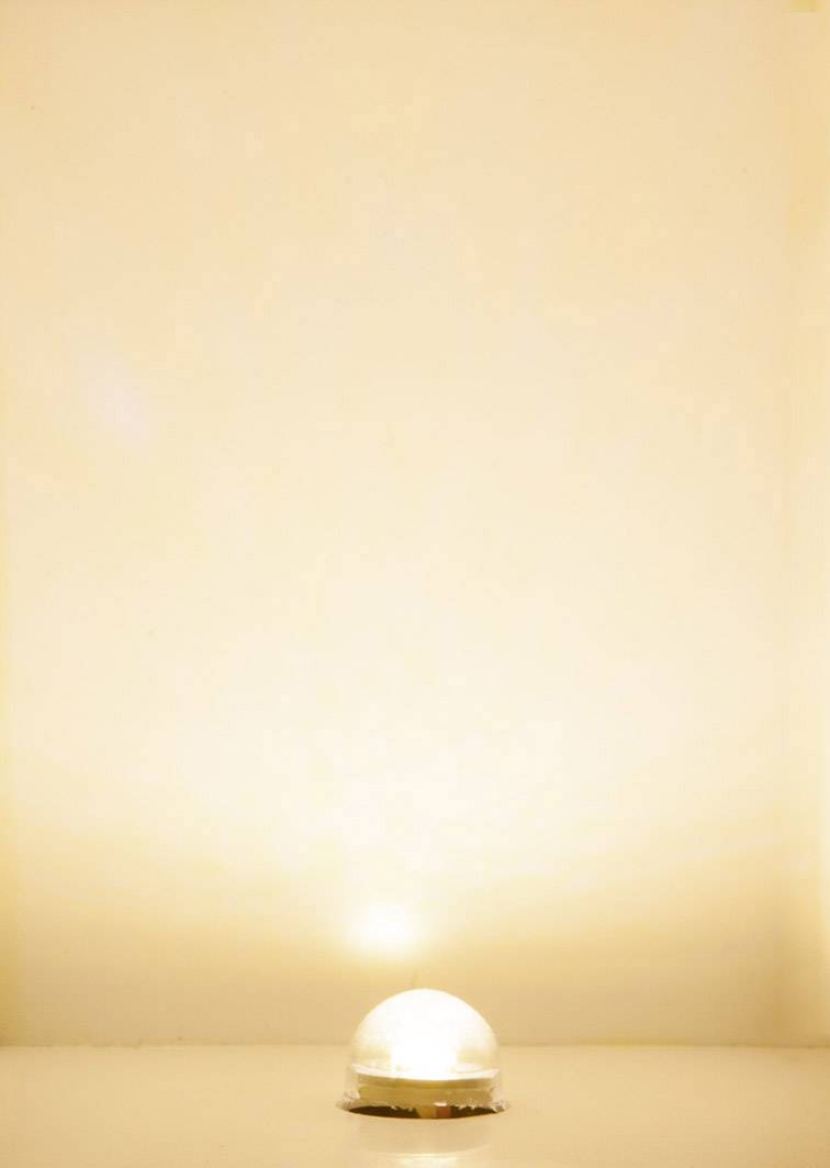 Small, spherical lamp that emits warm light in an otherwise empty, beige room.