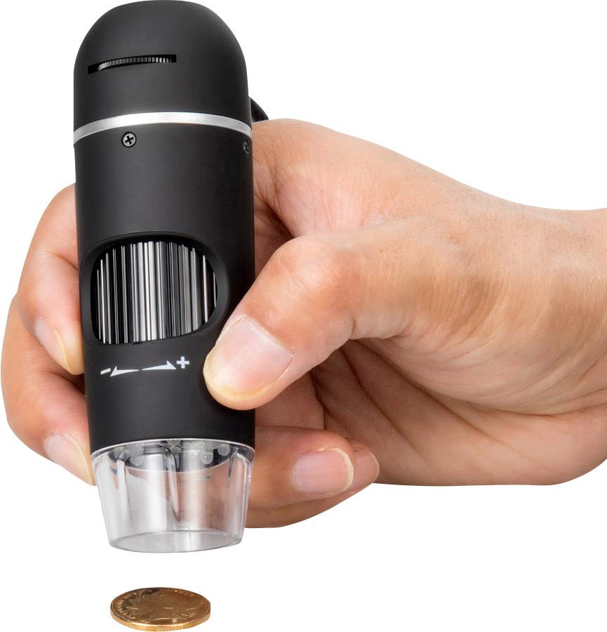 A hand holds a compact microscope over a coin on a white background, magnifying the details of the coin.