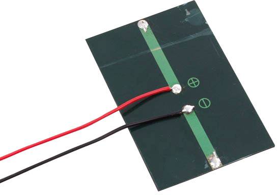 A rectangular solar module in dark green with two solder points, to which a red and a black cable are connected.