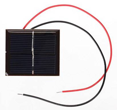 Small solar module with red and black cables, used for generating electricity from sunlight.