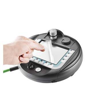 A hand removes a protective film from a screen on a round electronic device with buttons.