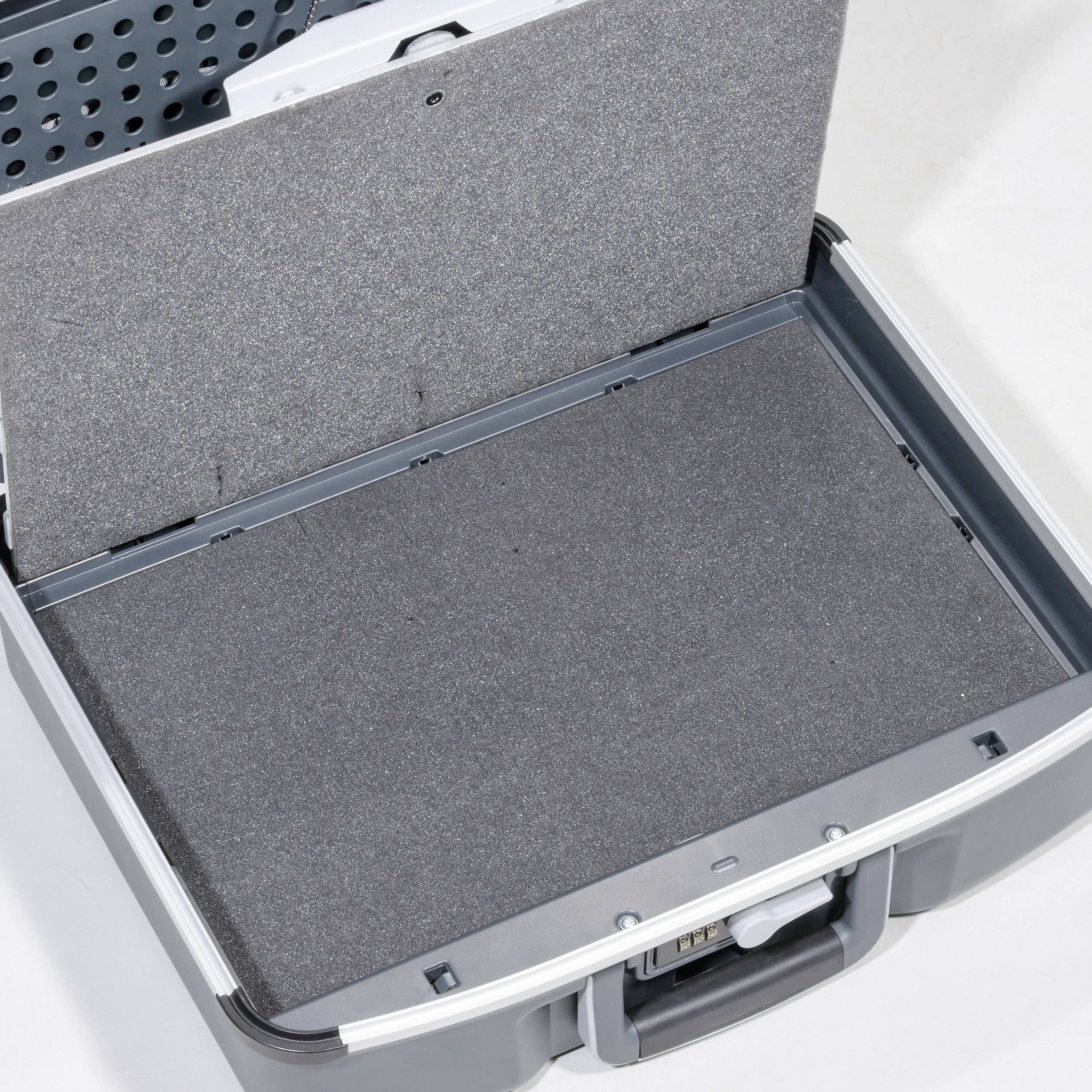 An empty, open grey suitcase with a dark inner lining against a light grey background.