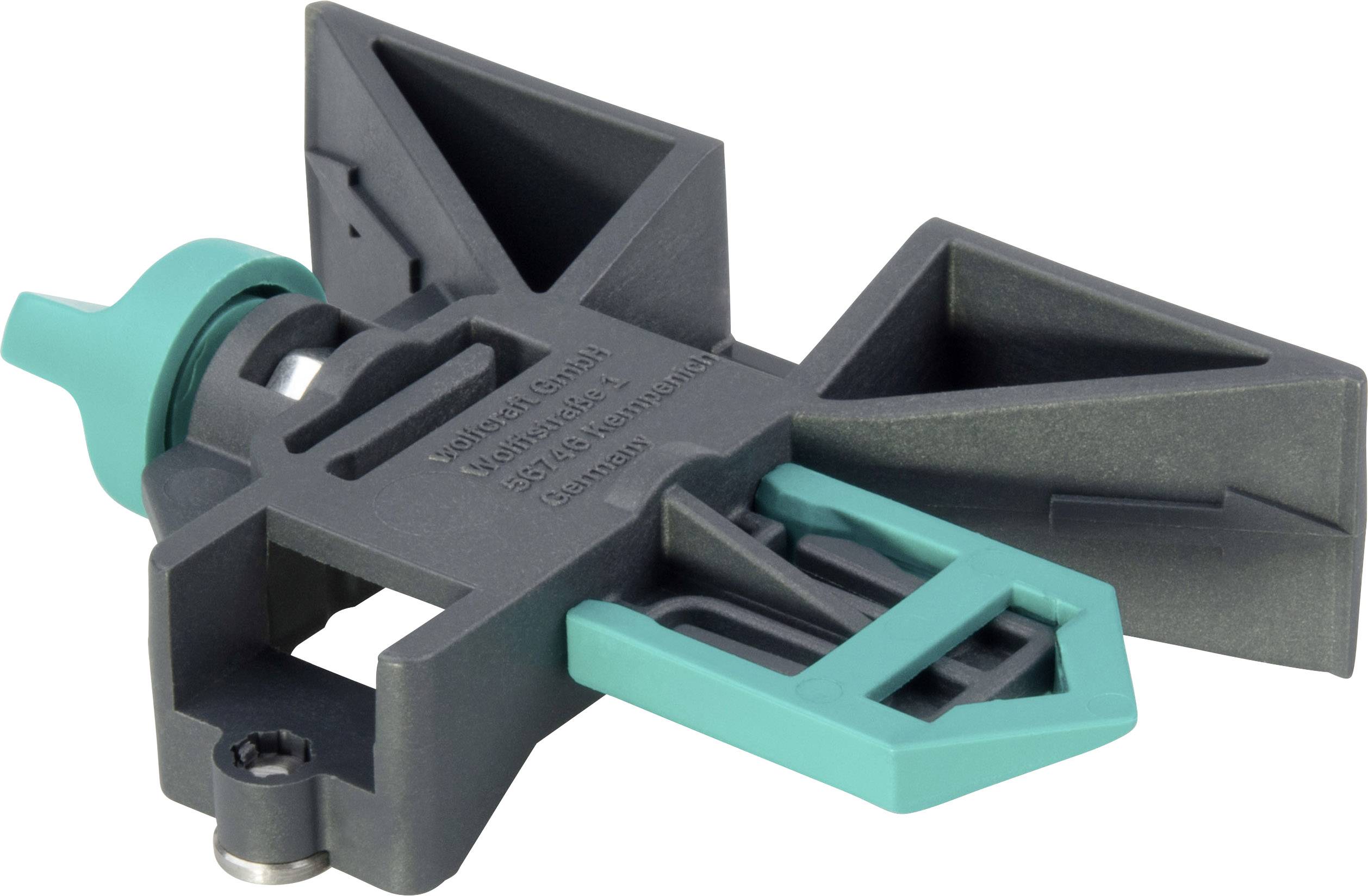 A black plastic component with green elements, possibly a connecting piece or part of a mechanical device.