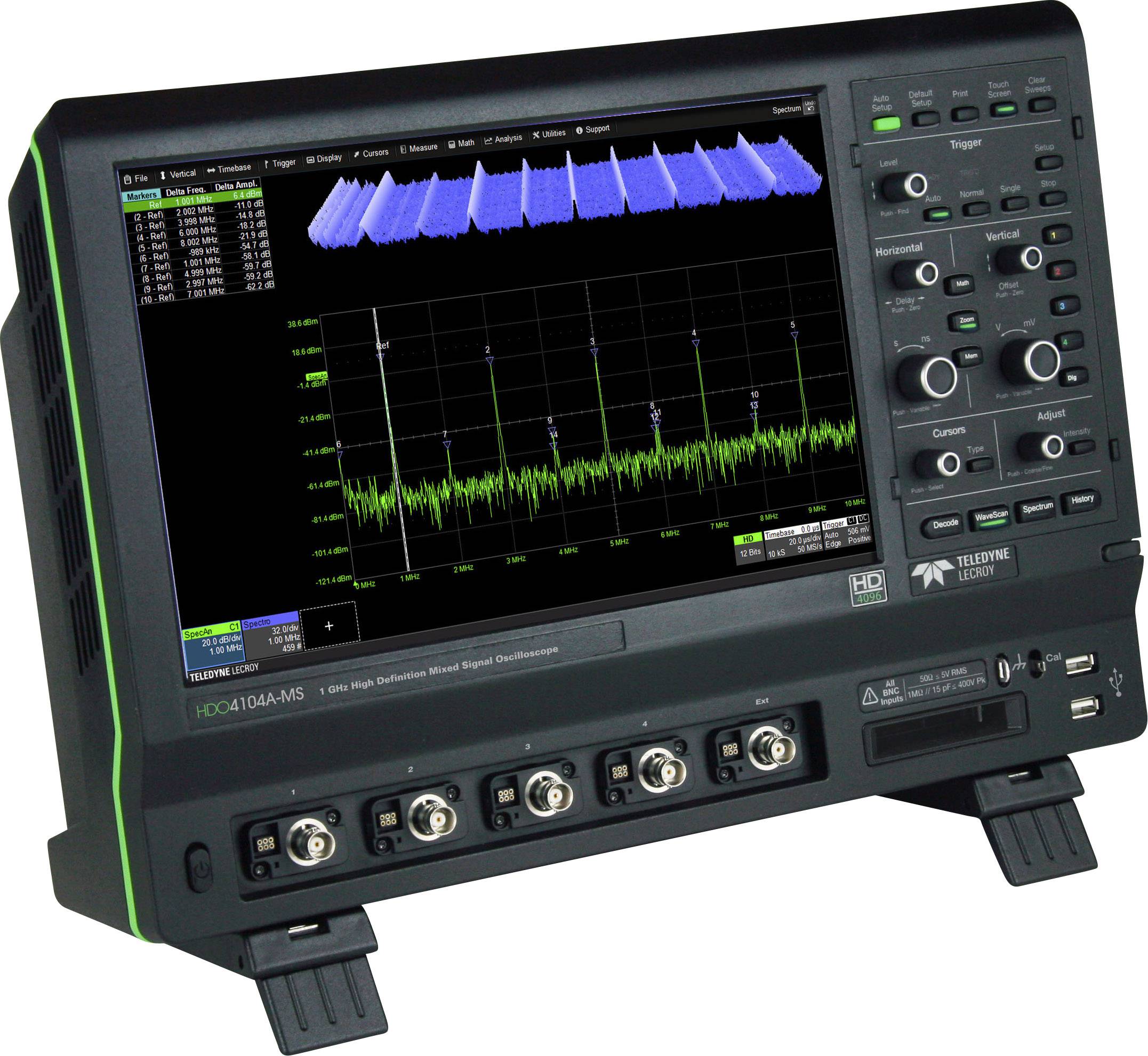 Oscilloscope with display showing frequency spectra and waveform. Device has buttons and connections on the front panel.