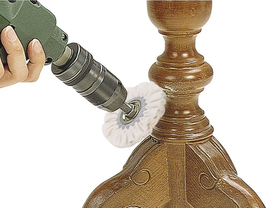 A person is polishing a piece of wooden furniture with an electric drill and a polishing attachment.