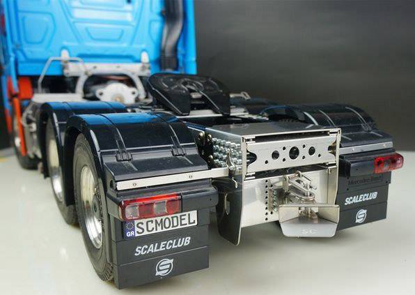 A model truck trailer with detailed parts and a blue cab is shown on a flat surface.