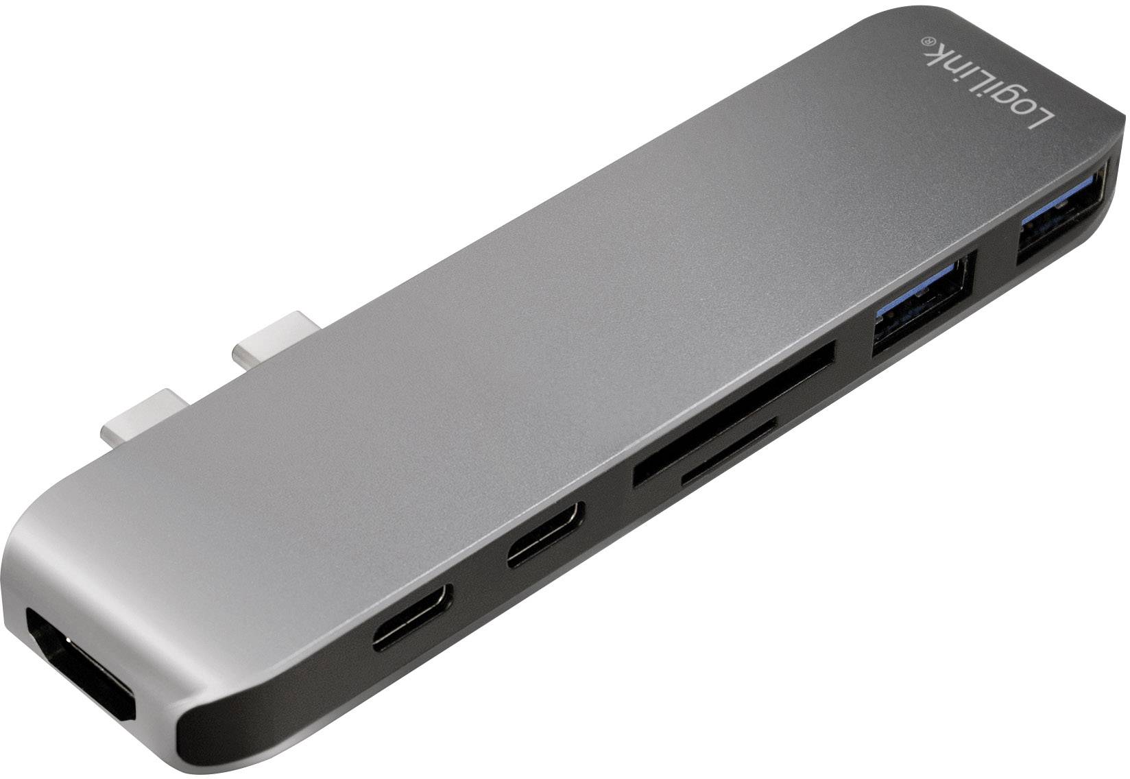 A silver USB-C hub with multiple ports, including HDMI, USB-A, USB-C and SD card slots, serves to expand device connectivity.