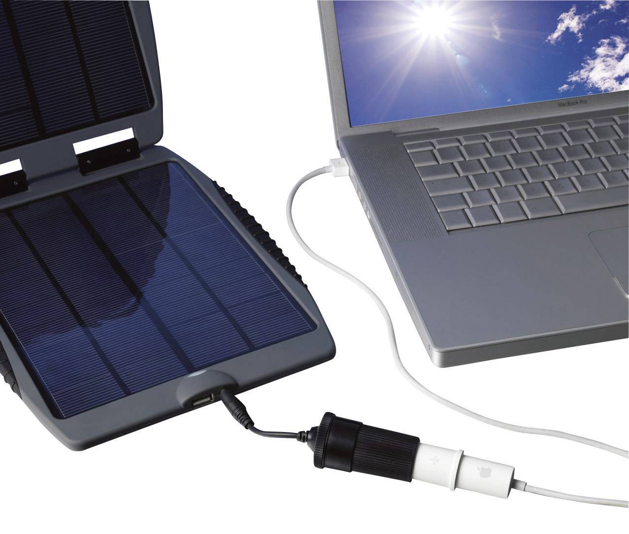 A portable solar panel charges a laptop under a sunny sky via a connected cable.