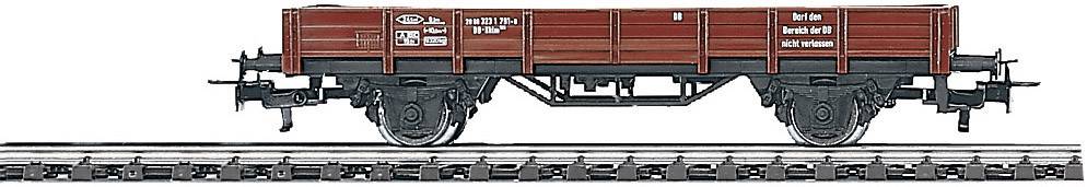 Red goods wagon on railway tracks, side view. Wagon has black wheels and white markings with technical details.