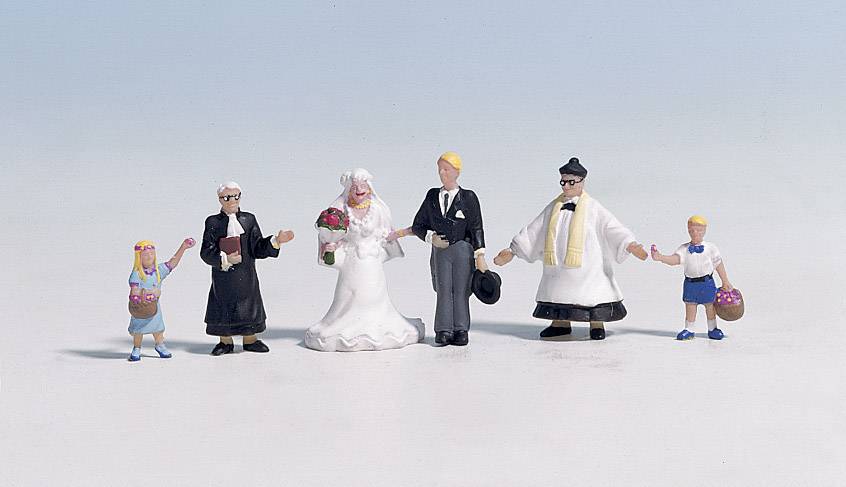 Miniature model of a wedding ceremony featuring a bride, groom, two children, and two adults dressed in formal attire.