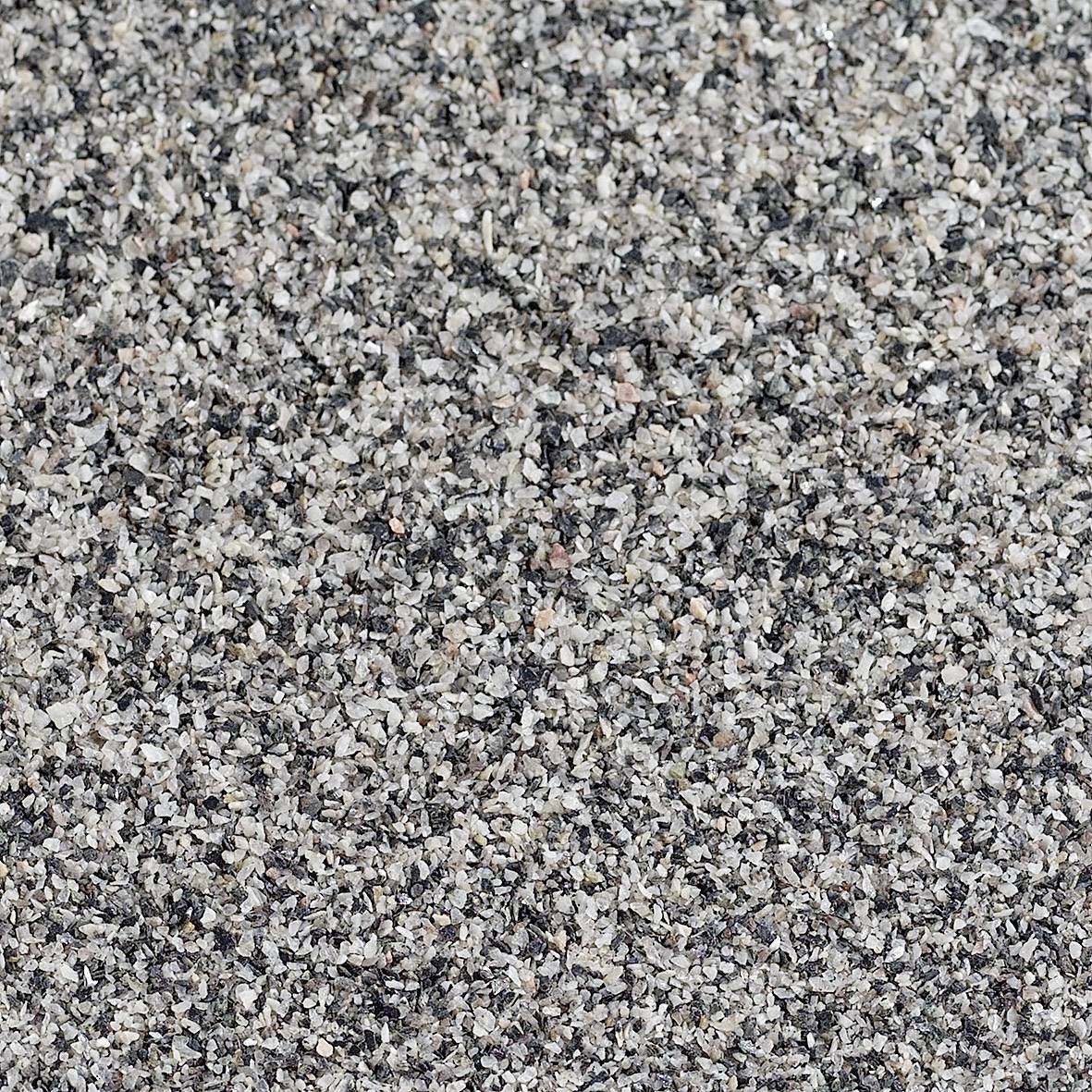 Close-up of coarse-grained, grey sand with grains in various shades of grey.