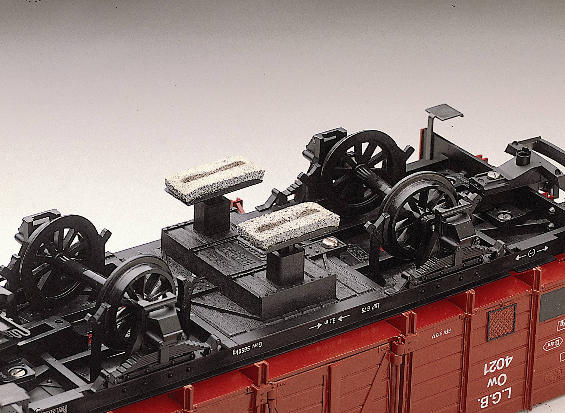 Underside of a model goods wagon with detailed representation of wheels and braking equipment. Focus on wheel suspension and mechanics.