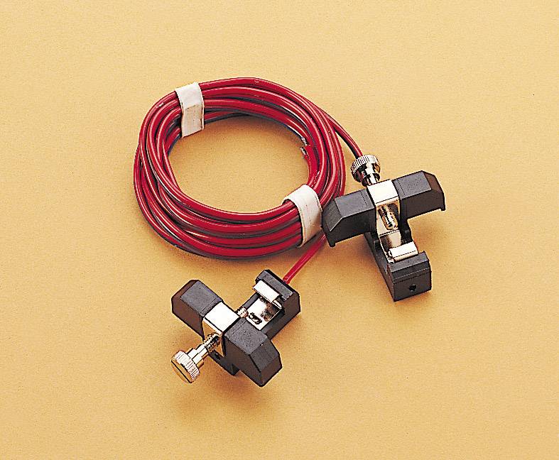Red cable wire with two black clamps on a beige background. Clamps are metallic, wire spirally bound.