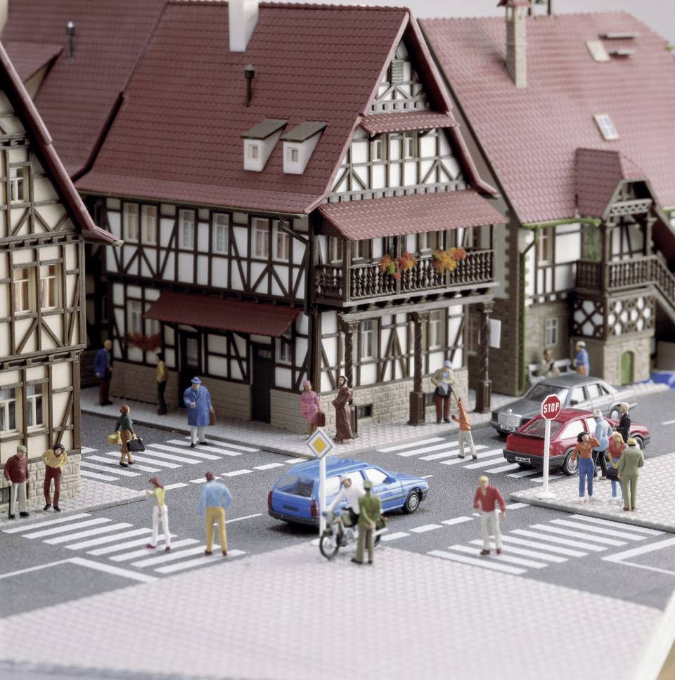 Street scene of a miniature village with half-timbered houses, cars and figures crossing zebra crossings. Traffic signs are visible.