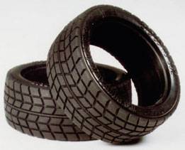 Two black car tyres with tread patterns are layered on top of each other on a light background.