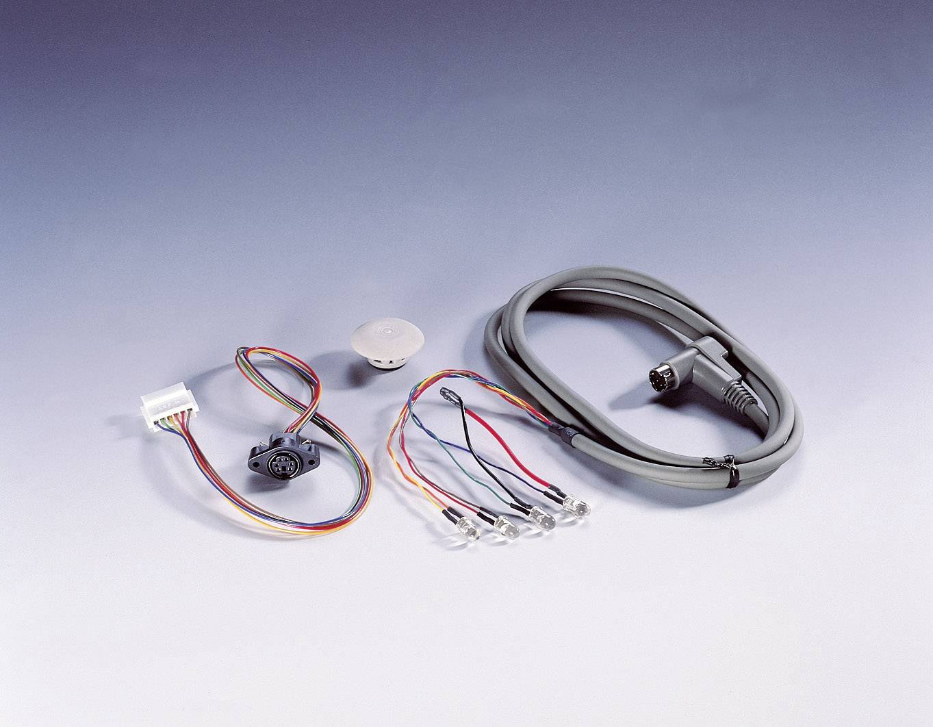 Multicoloured cables, plugs and connectors on a light blue background, used for electronic connections.