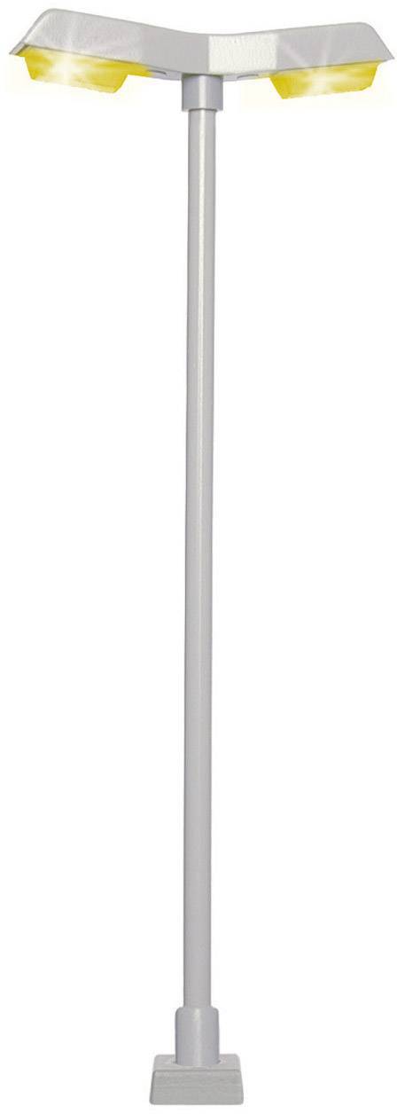 A modern street lamp with two yellow lights attached to a tall, slender pole.