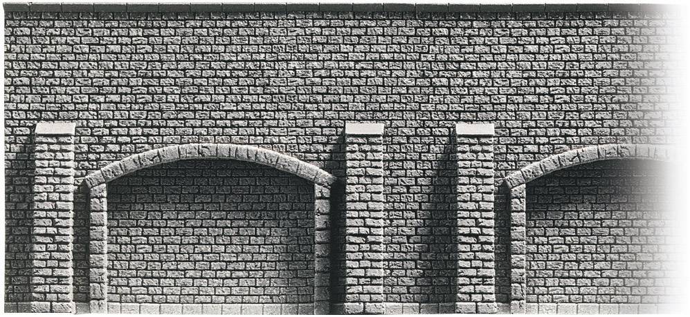 Stone wall with curved archways and vertical columns. Textured surface made of uniform brickwork.