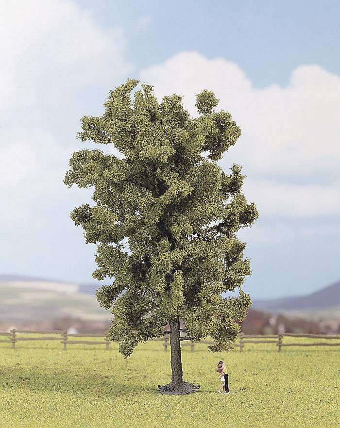 A small figure stands beside a large tree in a field. In the background, a wooden fence and a hilly landscape can be seen.