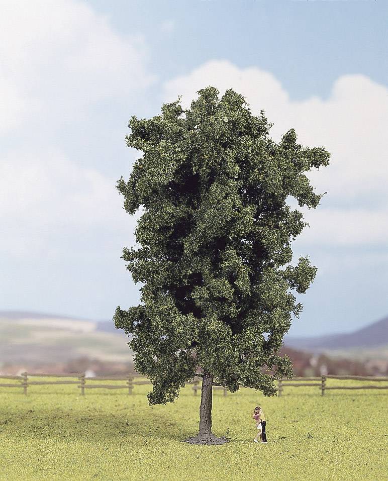 A large, green model of a tree stands on a meadow. A small figure of a child is playing underneath. A wooden fence can be seen in the background.
