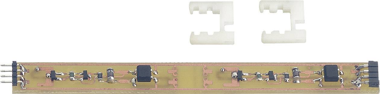 Shown is a long, narrow electronic circuit board with various electronic components and two plastic mountings.